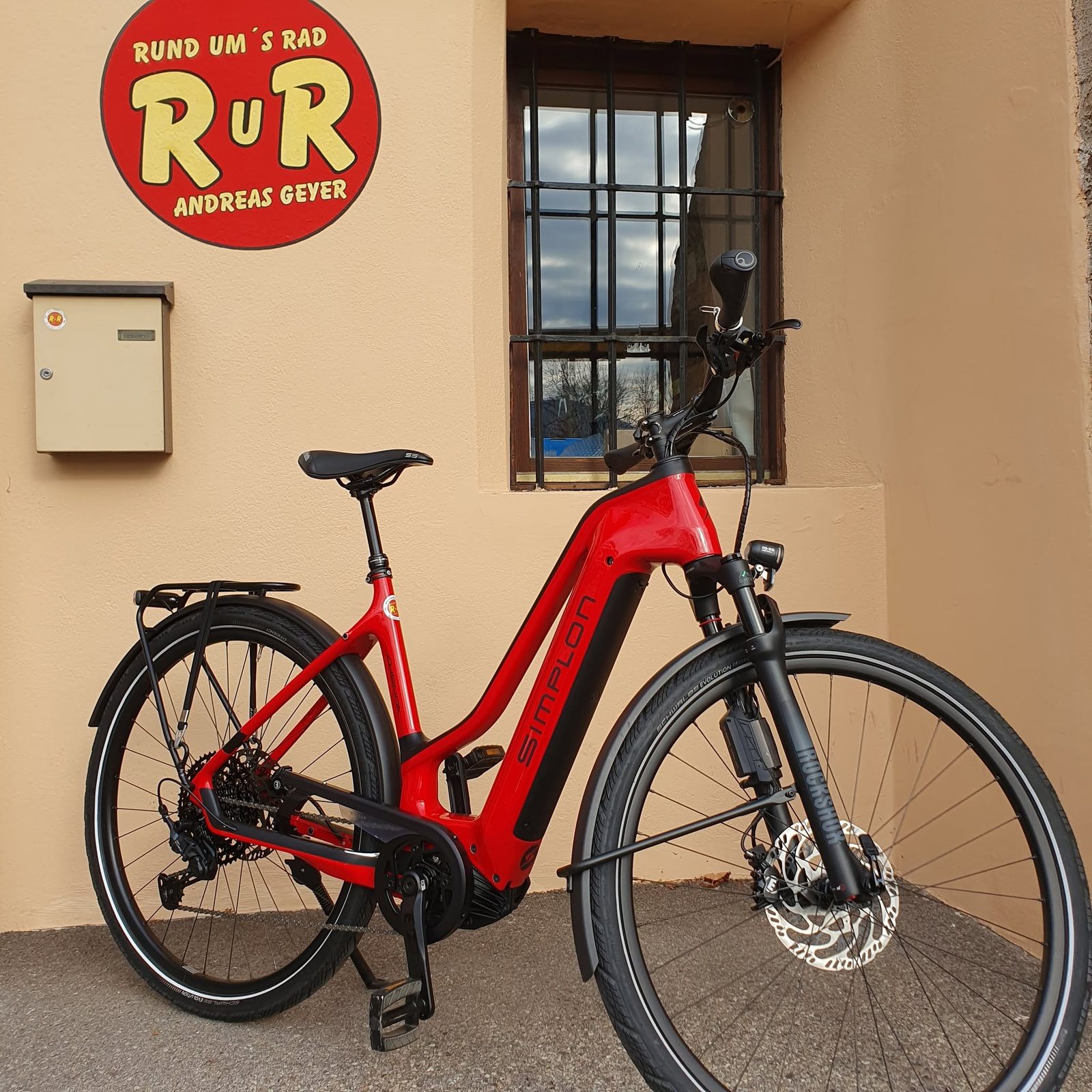 Rotes Simplon Trekking-E-Bike vor dem RuR-Schild